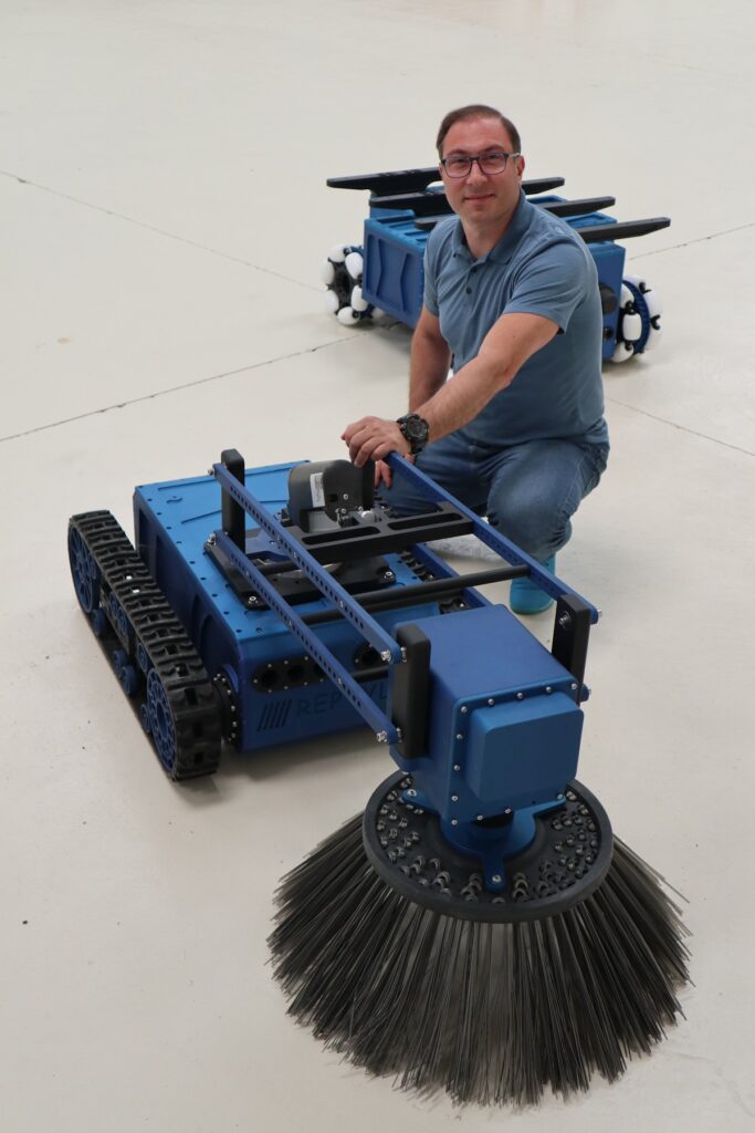 jean jacques topalian pose a cote de ses robots - robots de nettoyage - de depollution - de manutention - robots incendie - robots a visee militaire - tout est possible